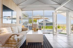 Nørre ÅbyにあるCozy Summer House In Føns With Sea Viewのソファとテーブルのあるリビングルーム