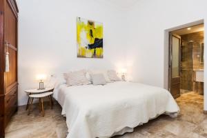 a white bedroom with a white bed and a table at Bouganvilla House in Ariany +12 photos
