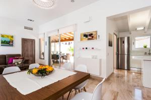 a dining room and living room with a table and chairs at Bouganvilla House in Ariany