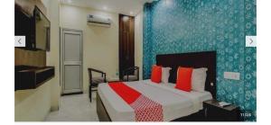a bedroom with a large bed with red pillows at Hotel O Alpine in Chandīgarh