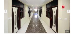 a corridor of a hallway with doors and a floor at Hotel O Alpine in Chandīgarh