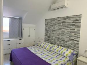 a bedroom with a bed and a brick wall at Stunning sea view Tenerife Royal Gardens Resort! in Playa de las Americas +24 photos