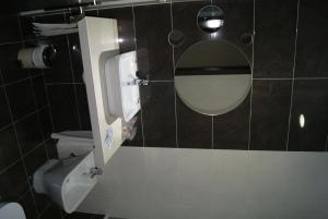 a bathroom with a mirror and a toilet at Hotel Doña Luisa in San Luis de Sabinillas