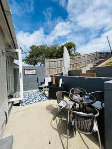 a patio with a table and chairs and stairs at Peaceful location with FREE parking for 2 cars - hosts up to 4- business or leisure stays, inc hot-tub-Netflix-complimentary breakfast in Southampton