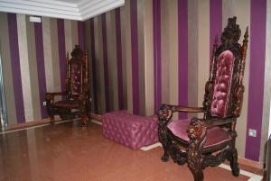 a room with two chairs and a ottoman at Hotel Doña Luisa in San Luis de Sabinillas