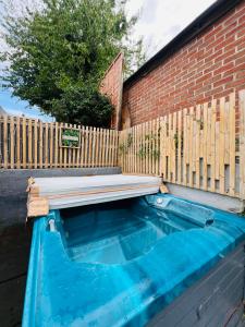 a pool of water next to a wooden fence at Peaceful location with FREE parking for 2 cars - hosts up to 4- business or leisure stays, inc hot-tub-Netflix-complimentary breakfast in Southampton