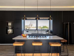 a kitchen with black walls and a kitchen island with a window at DAR PITXI - Personnel inclu in Essaouira