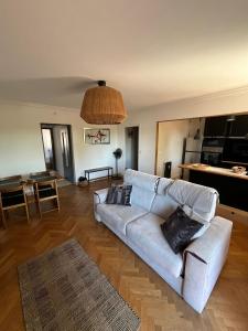a living room with a white couch and a table at Le Relais des Cyclamens Bron in Bron
