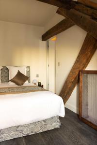 a bedroom with a large white bed and wooden beams at Hotel Palais Bourbon in Paris +122 photos