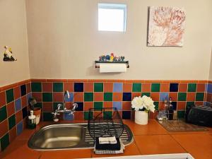a kitchen counter with a sink and colorful tiles at Bergvliet Cottages - Salvado and Esparanza in Clarens +91 photos