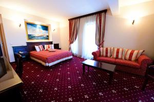 ティミショアラにあるHotel Imperial Timisoara by JRのベッドとソファのあるホテルの部屋 +24枚の写真