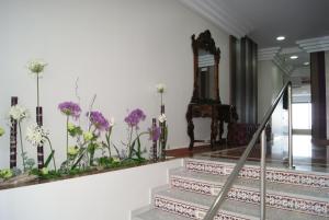 a staircase with purple flowers on the wall at Hotel Doña Luisa in San Luis de Sabinillas