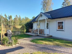 a small white house with a picnic table in the yard at Charming cottage on Kvegero in Gnesta