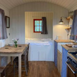 a kitchen with a table and a window in a room at Secluded off grid Shepherd's Hut in Minchinhampton