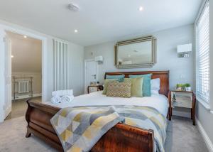 a bedroom with a bed and a mirror on the wall at Harper Luxe Serviced Apartments Dunstable in Dunstable