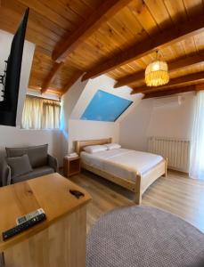 a bedroom with a bed and a couch and a table at Gegest Hotel in Theth