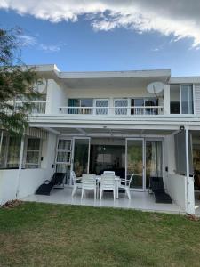 a white house with a table and chairs at Holiday home by the River with Jetty in Port Alfred