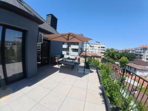 a patio with a table and an umbrella at Azur by Gergana in Bŭnzareto