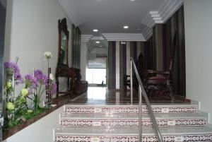 a hallway with stairs with purple and white flowers at Hotel Doña Luisa in San Luis de Sabinillas