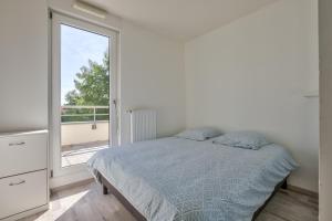 a bedroom with a bed and a large window at Stunning 2BR Flat with Terrace and private parking in Strasbourg