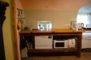 a kitchen with a counter with a sink and a microwave at Srub v županu in Prachatice +1 photo