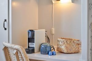 a shelf with a coffee maker and a basket on it at Klippen Hotel - Therns in Gudhjem +25 photos