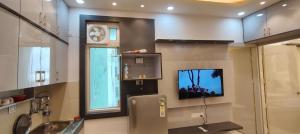 Habitación con baño con TV y lavabo. en Paradise, en Haridwar 2 fotos más