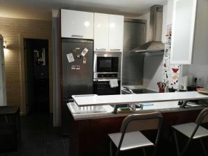 a kitchen with a stainless steel refrigerator with magnets at Apartamento Playa relax in La Estrella