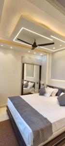 Un dormitorio con una cama grande con ventilador de techo. en Paradise, en Haridwar