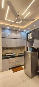Una cocina con gabinetes blancos y un refrigerador de acero inoxidable. en Paradise, en Haridwar