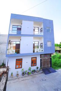 un edificio blanco con puertas y ventanas de color naranja en The Taj Wings Home Stay, en Agra