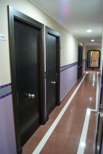 a hallway with black doors and a tile floor at Hotel Doña Luisa in San Luis de Sabinillas