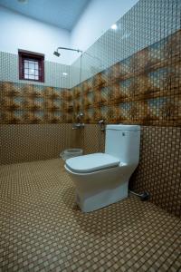 KanthalloorにあるMythree Mistのトイレとタイル張りの壁があるバスルーム