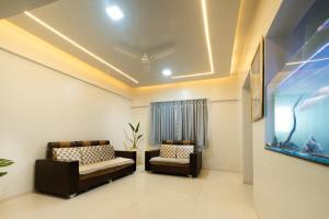 un soggiorno con 2 sedie e un acquario di Star Ashiyana Near Airport 2bhk Spacious Flat a Kolhapur
