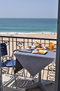 a table on a balcony with a view of the beach at Hotel Mar Bravo in Nazaré