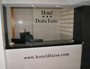 a hotel desk with a sign on the wall at Hotel Doña Luisa in San Luis de Sabinillas