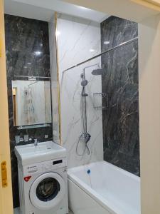 a bathroom with a washing machine and a bath tub at DREAM HOUSE TASHKENT Airtport in Stantsiya Kyzyl-Tukumachi