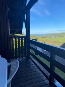 - une terrasse couverte avec des chaises et une vue sur un champ dans l'établissement Chalet 6 personnes Besse et Saint Anastaise, à Besse-et-Saint-Anastaise