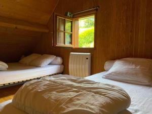 une chambre avec deux lits et une fenêtre dans l'établissement Chalet 6 personnes Besse et Saint Anastaise, à Besse-et-Saint-Anastaise