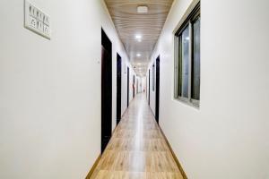 a hallway with white walls and a wooden floor at Super Collection O Ulife in Mumbai