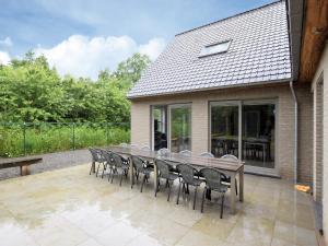 a wooden table and chairs on a patio at Luxurious Home with Sauna in Somme-Leuze