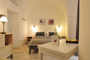 a bedroom with a bed and a table with a bag at Porta San Michele in Gravina in Puglia