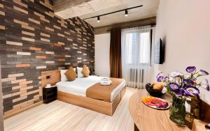 a bedroom with a bed and a table with flowers at Rooms Apart Hotel by RED in Yerevan