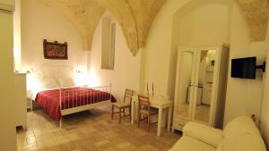 グラヴィーナ・イン・プーリアにあるPorta San Micheleのベッドルーム1室(ベッド1台、テーブル、椅子付)