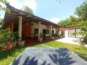 una casa con un porche con plantas en el patio en The Villa Hush - 02, en Hikkaduwa