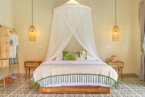 1 dormitorio con 1 cama con dosel y 2 mesas en LePalms villa, 2min Beach, 10min Atlas,Finns Club, en Canggu