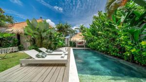 Un patio trasero con piscina y terraza de madera. en LePalms villa, 2min Beach, 10min Atlas,Finns Club, en Canggu