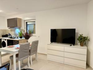 a living room with a television on a white dresser at Apartment MiRa 2 in Pulheim