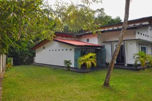 une maison blanche avec une cour devant elle dans l'établissement Sunny Boutique Villa, à Tangalle