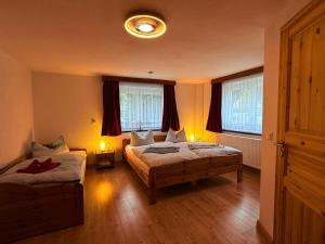 a bedroom with two beds and two windows at Naturhof Kluge in Saupsdorf